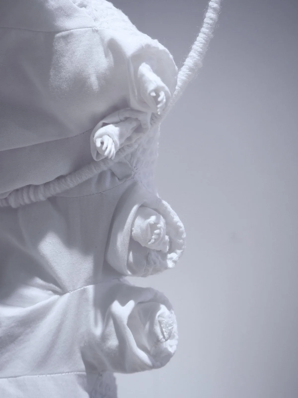 〈모낭충〉, 2025, 헌 면 베갯잇, 면 실, 솜, 3D 프린팅 한 작은 인간 손, 109 × 29 × 16 cm